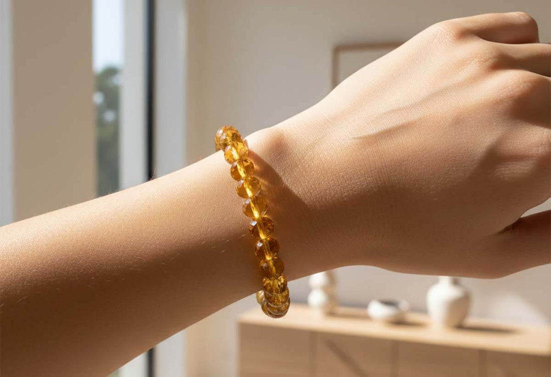 Woman wearing natural citrine bracelet on wrist in warm sunlight showcasing golden yellow gemstone beads