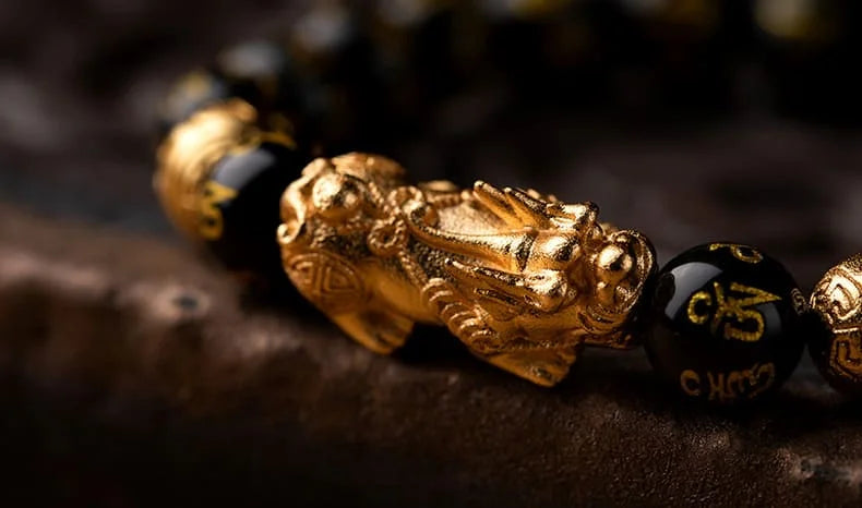 Side view of black obsidian bracelet with gold-plated Pixiu symbolizing wealth and power