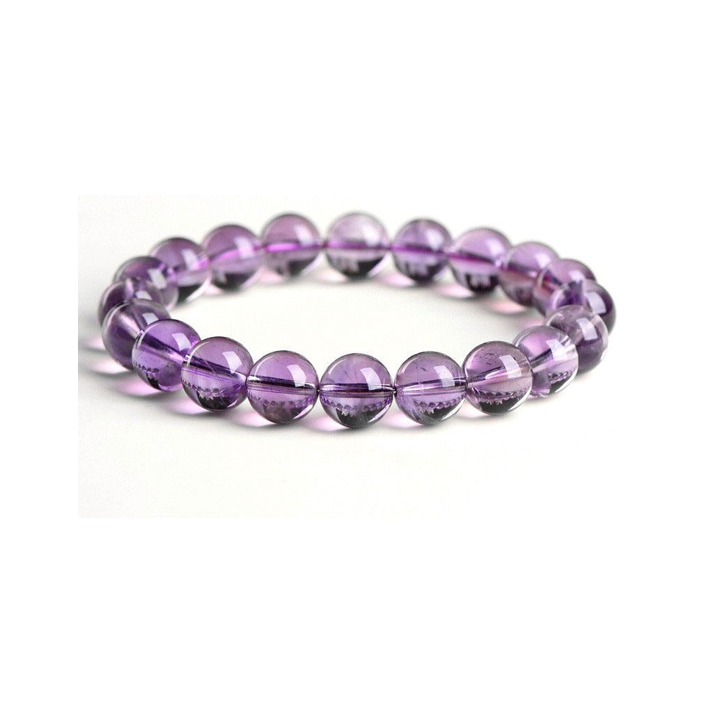 Close-up of polished amethyst crystal beads showing vitreous luster and natural inclusions