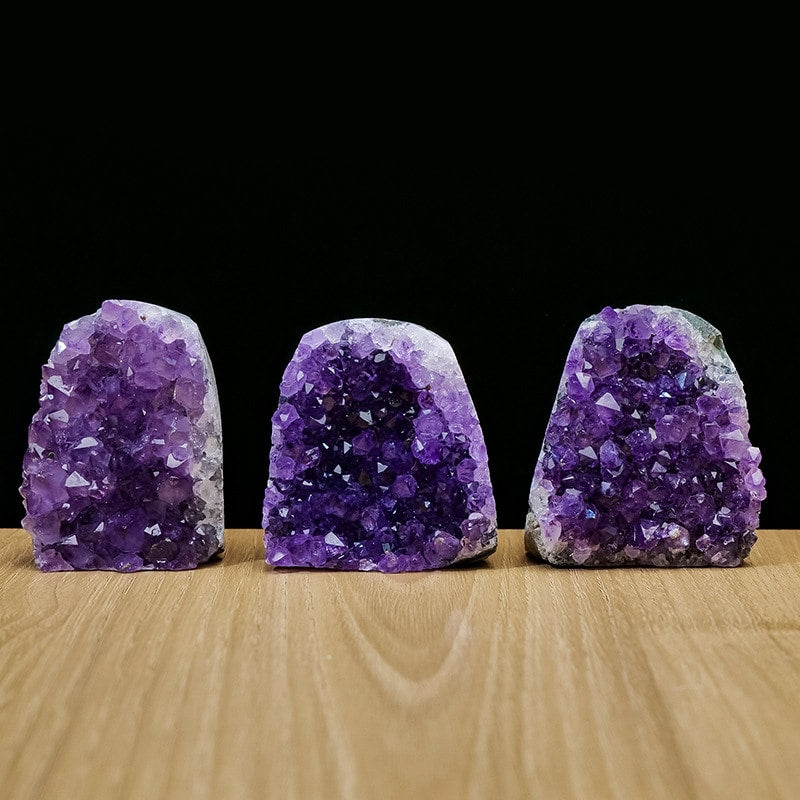 Three amethyst geode decor pieces grouped on tabletop
