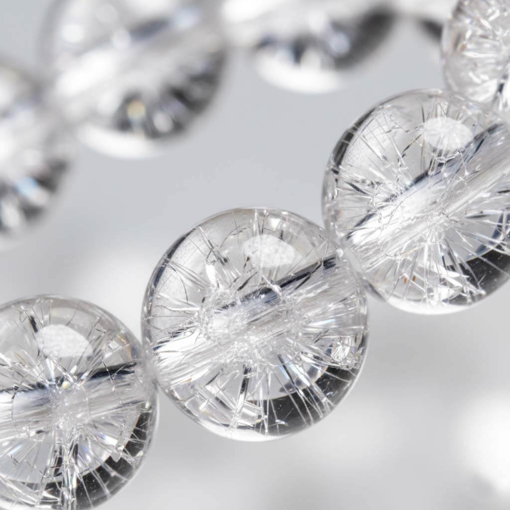 Close-up of Clear Quartz beads showing ice-cracked internal fractures and firework effect