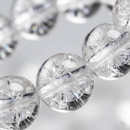 Close-up of Clear Quartz beads showing ice-cracked internal fractures and firework effect