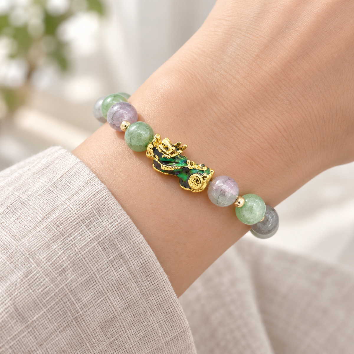 Color-changing Pixiu bracelet worn on the wrist with mixed green, lavender and gray beads