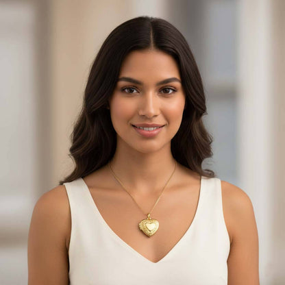 Woman wearing gold tone heart photo locket necklace showing engraved floral pattern at collarbone length for personalized jewelry.