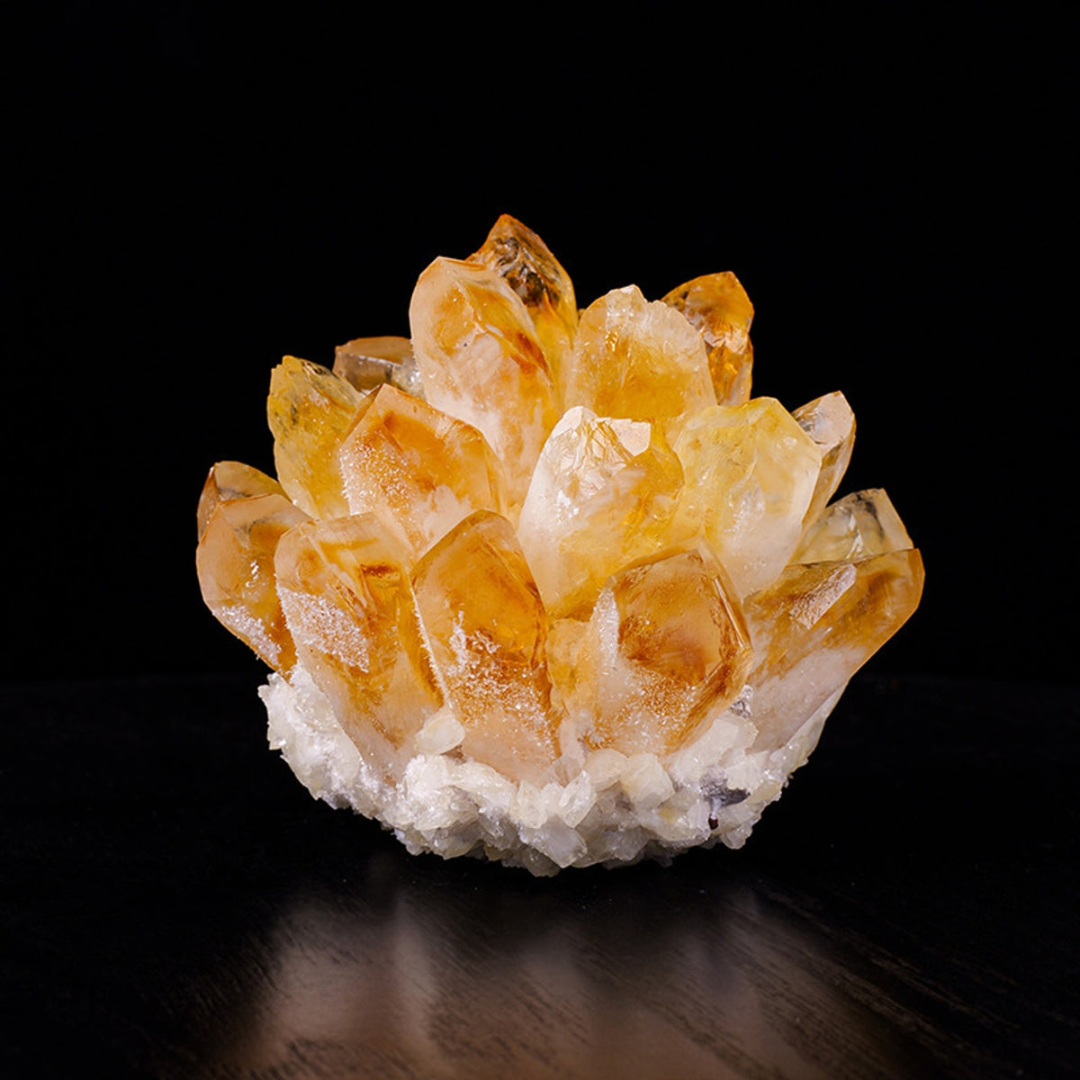 Golden citrine crystal cluster decor on black display surface