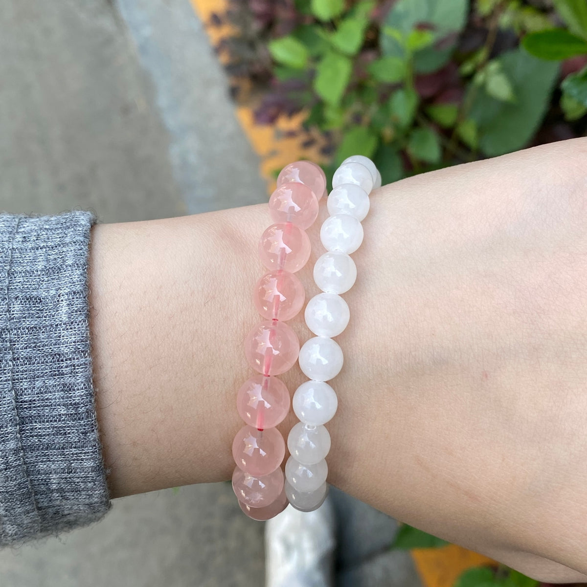 White jade bracelet styled with a soft pink bead bracelet on wrist
