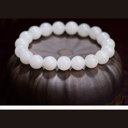 Hetian white jade round bead bracelet displayed on a dark carved wood stand