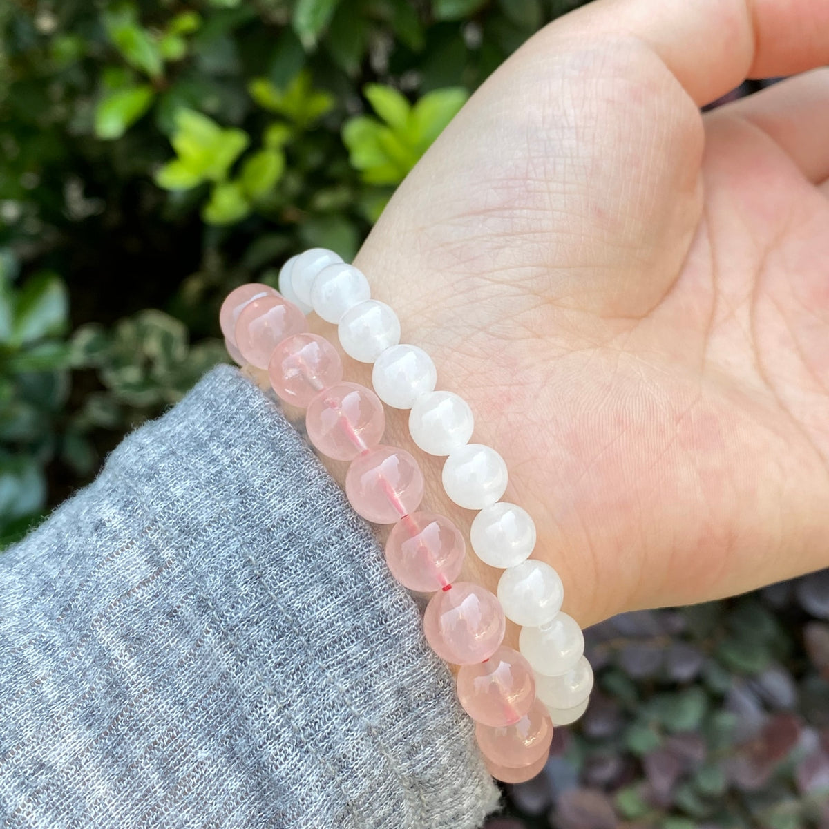 White jade round bead bracelet worn on wrist outdoors