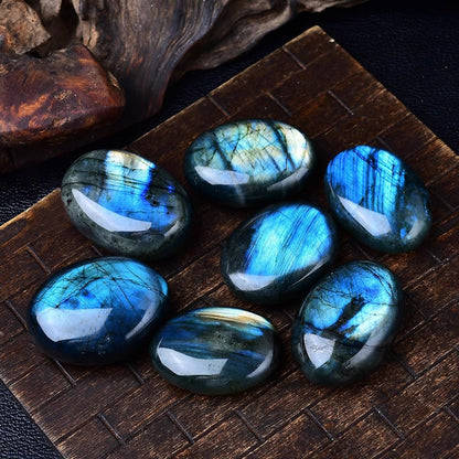 Natural labradorite palm stones with blue flash on dark display