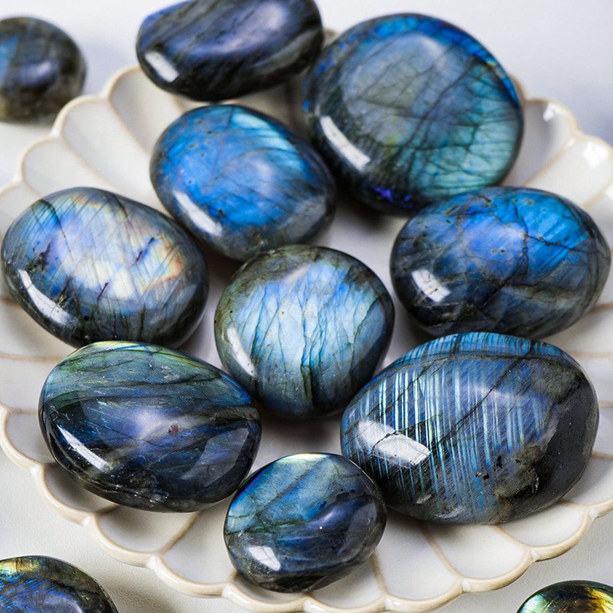 Labradorite palm stones on a white ceramic dish