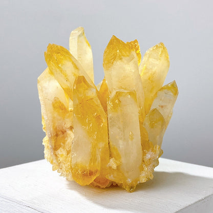 Light citrine crystal cluster decor on a clean display surface