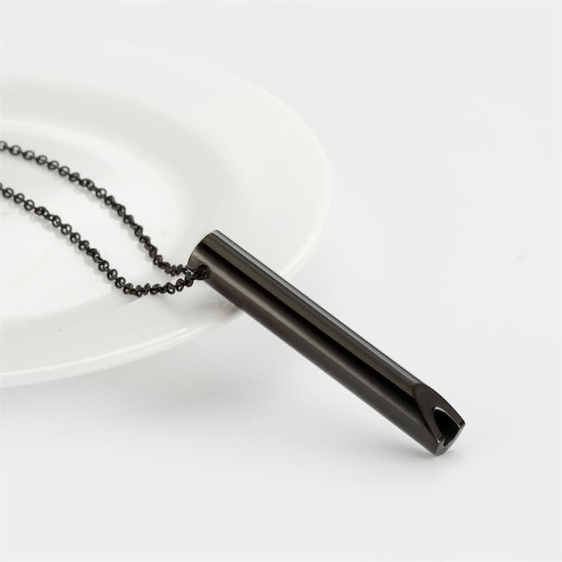 Matte black PVD coated whistle pendant on stainless steel chain showing minimalist cylindrical design and open whistle end detail