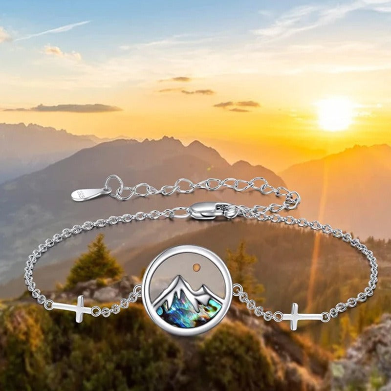 Mustard seed mountain bracelet shown against a warm mountain sunset background