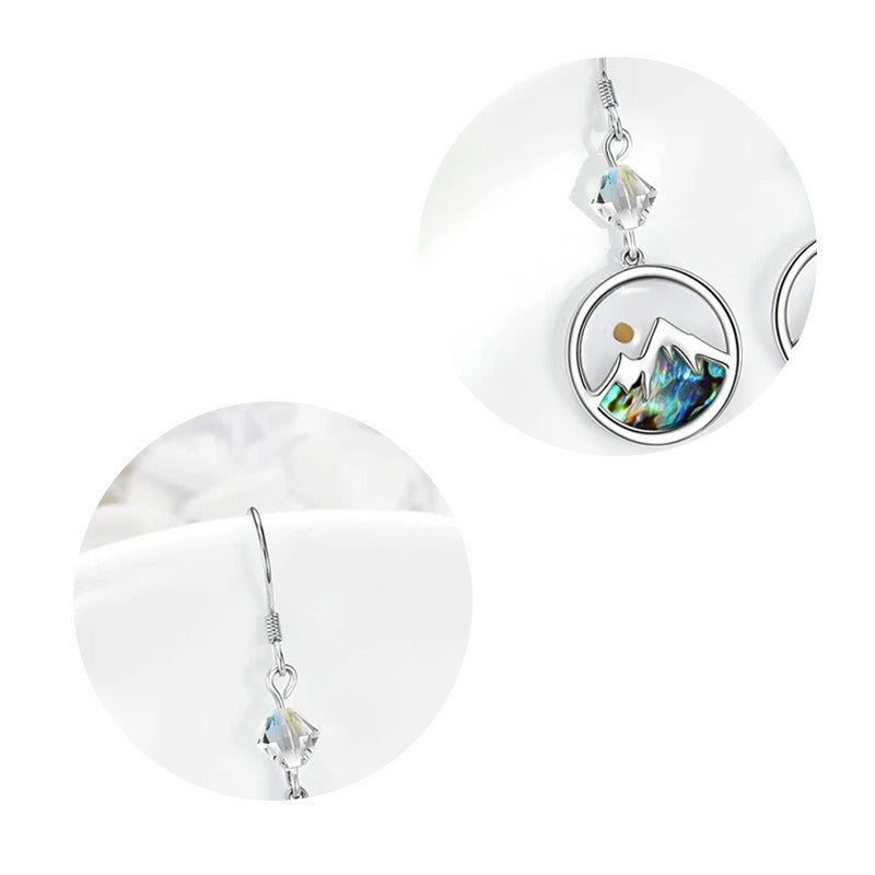 Close-up detail of mustard seed mountain earrings with crystal hook and round pendant