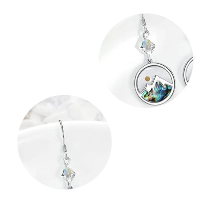 Close-up detail of mustard seed mountain earrings with crystal hook and round pendant