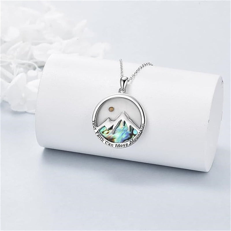 Mustard seed mountain pendant necklace displayed on a white jewelry roll