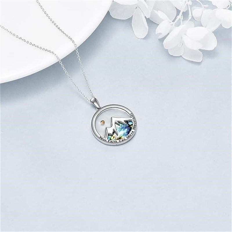 Mustard seed mountain pendant necklace with silver chain on a soft white background