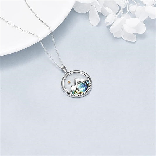 Mustard seed mountain pendant necklace with silver chain on a soft white background