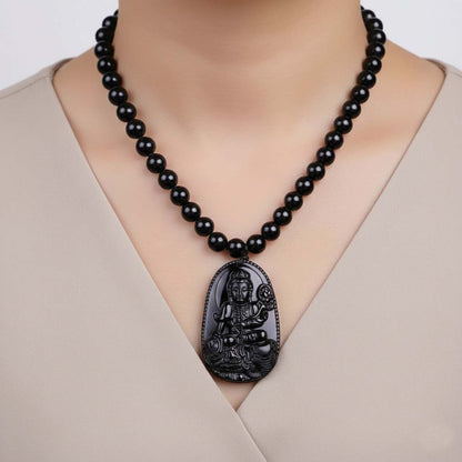 Person wearing Obsidian Pendant featuring traditional Buddhist artistic heritage