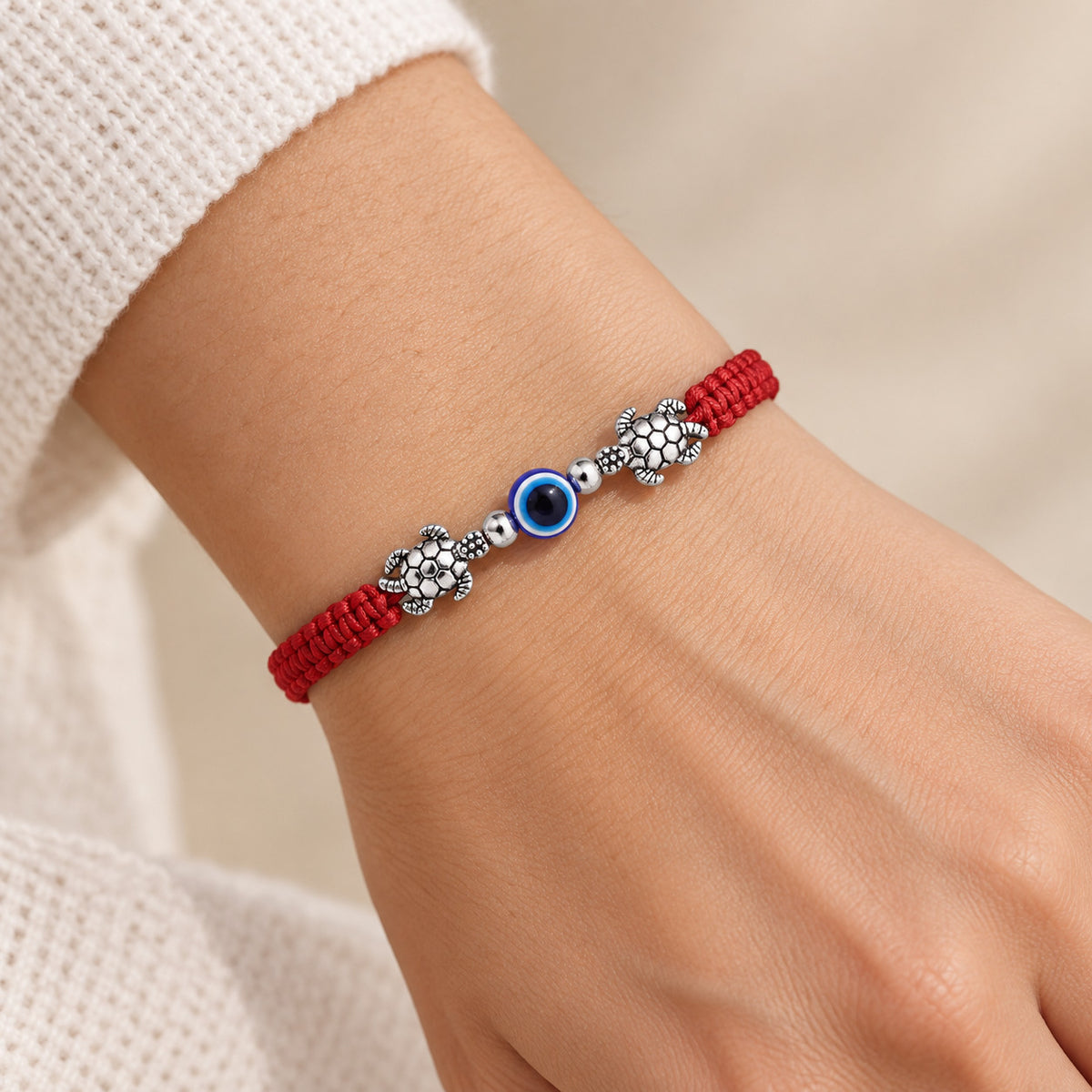 Close-up of red string turtle evil eye bracelet on the wrist