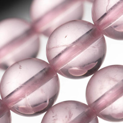 Macro view of Rose Quartz beads highlighting the natural translucent clarity and smooth vitreous luster.