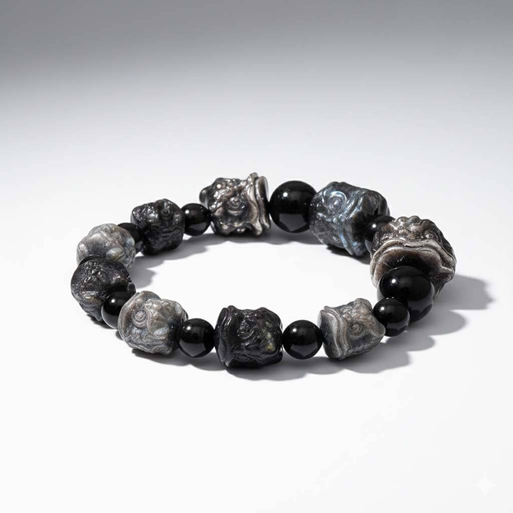 Silver Sheen Obsidian lion bracelet displayed with natural stone jewelry collection on desk