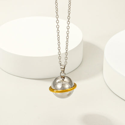Stainless steel memorial orb necklace with gold-tone ring accent on a light display