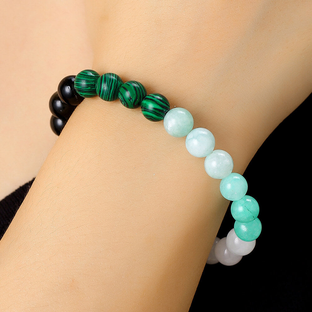 Woman wearing a 7-color natural stone bracelet on the wrist showing the elastic fit and vibrant bead style for daily wear.